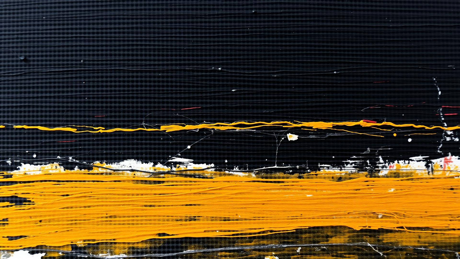 Close-up of thick black and ochre brushstrokes on canvas.